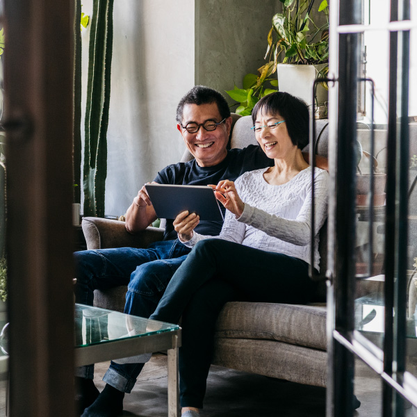 couple sitting in the sunroom on their tablet