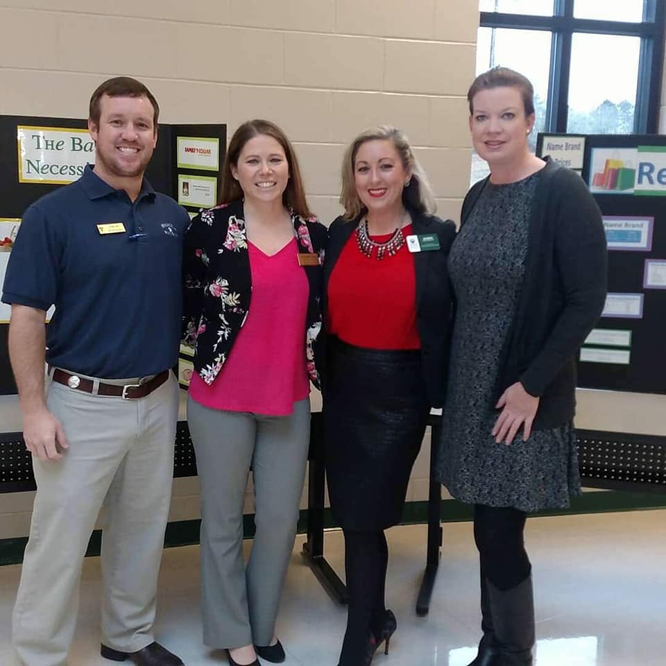 four adults smile at camera