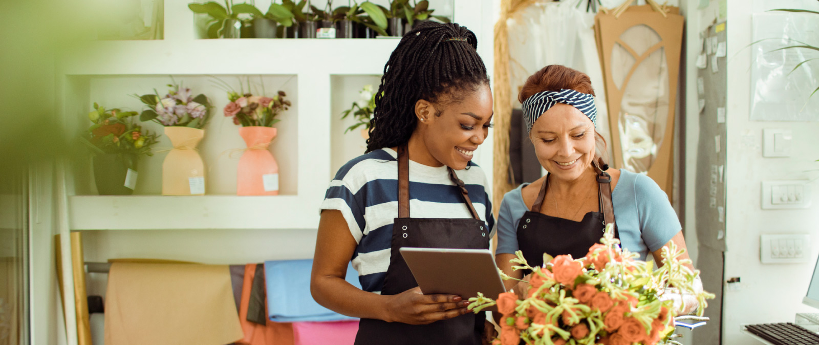 friends working in their floral shop with tablet