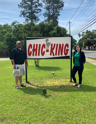 Photo of employee Ariel Bowley and customer Brannon Lynn in front of Chic King sign.
